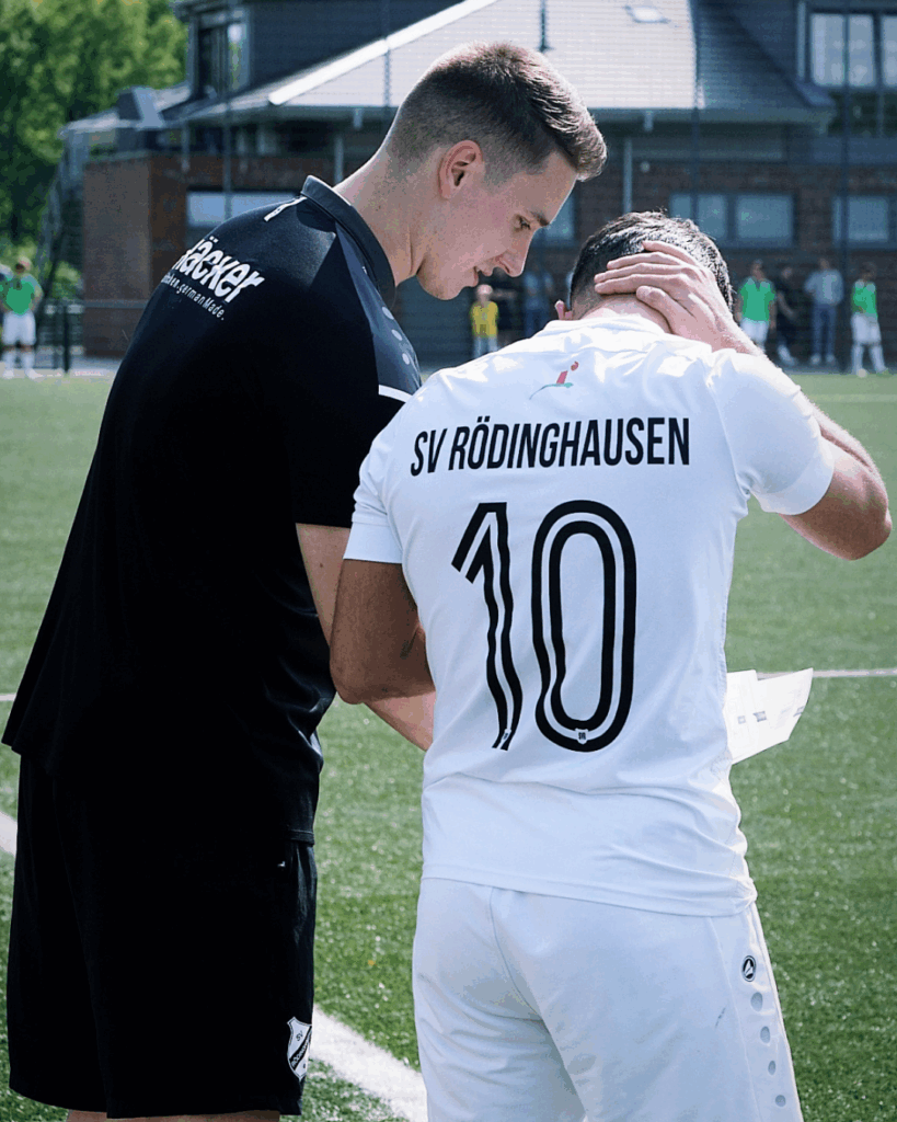 Ein Fußballtrainer des SV Rödinghausen gibt einem Spieler Anweisungen vor seiner Einwechslung.